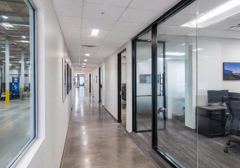 Pasillo de oficinas remodeladas con cancelería de vidrio