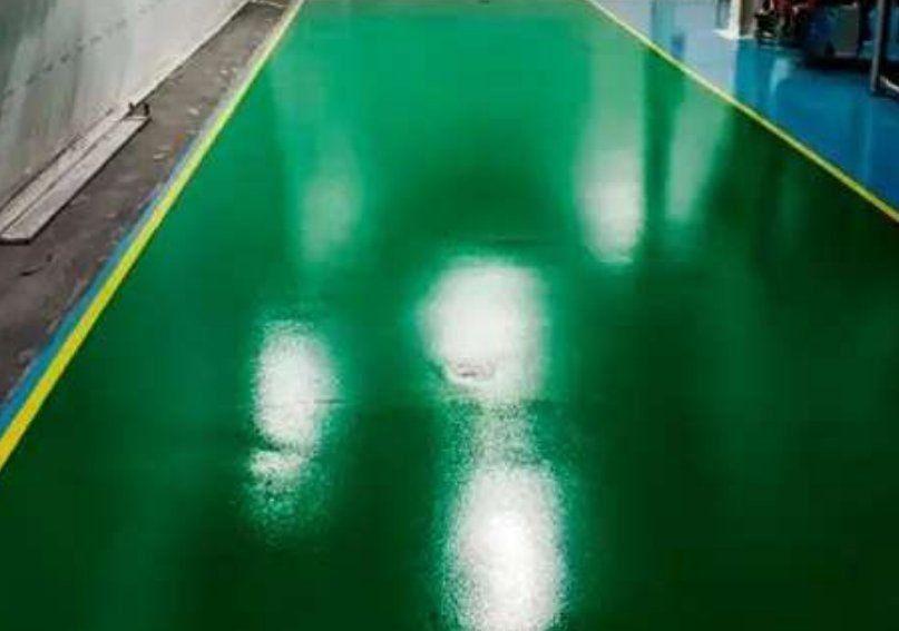 Piso epóxico verde con franjas de seguridad